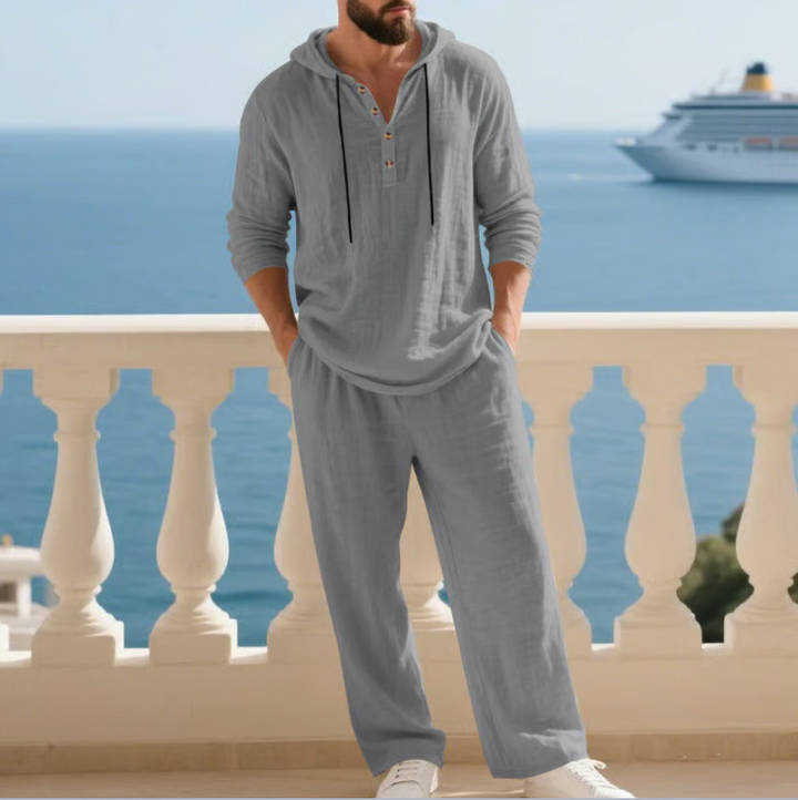 Model draagt stijlvolle heren zomerset 2-delig, ontspannen pasvorm. Comfortabele casual kleding voor de zomer.