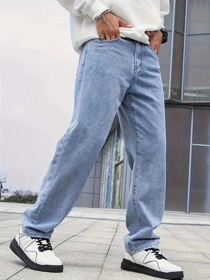Man draagt comfortabele herenjeans met rechte pijpen en lichte wassing, perfect voor een moderne casual look.