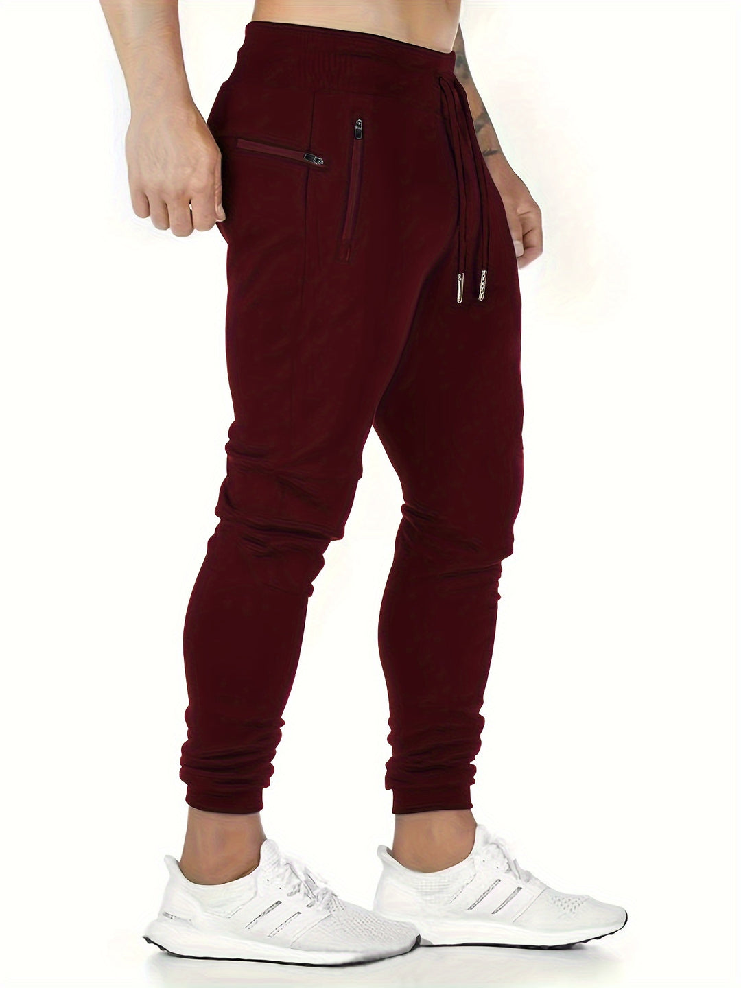 "Kastanjebruine heren joggingbroek van lichtgewicht polyester met ritszakken en trekkoord, ideaal voor lente en herfst."