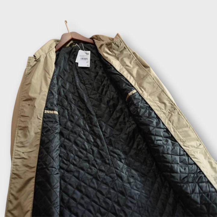 Stijlvolle herenjas, een lange trenchcoat met knoopsluiting en reverskraag, essentieel voor koude dagen.