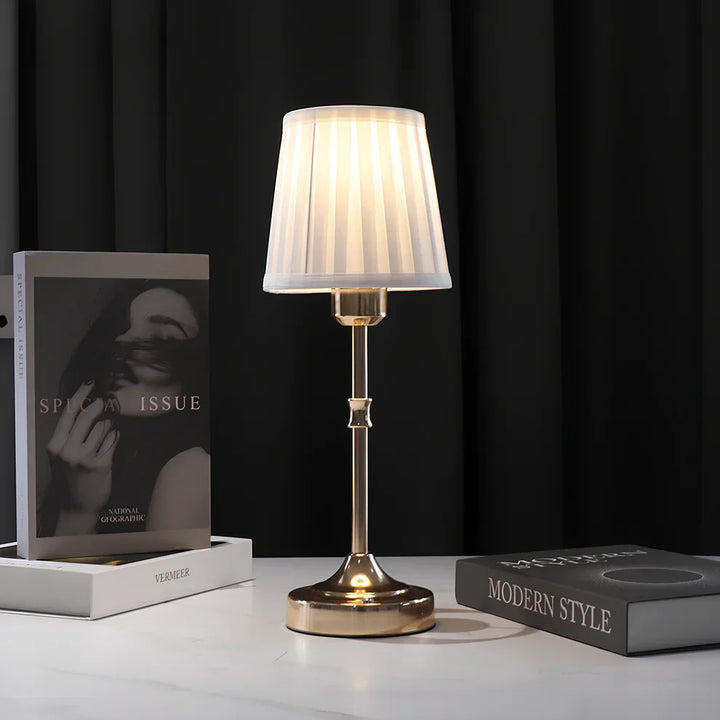 "Klassieke tafellamp met metalen frame en stoffen kap in een interieur, draadloos met drie lichtstanden."