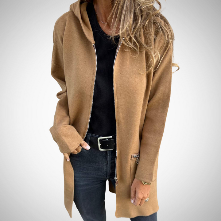 Comfortabel lang dames vest met capuchon, zacht gebreid voor warmte, ideaal voor wintermode en ontspanning.