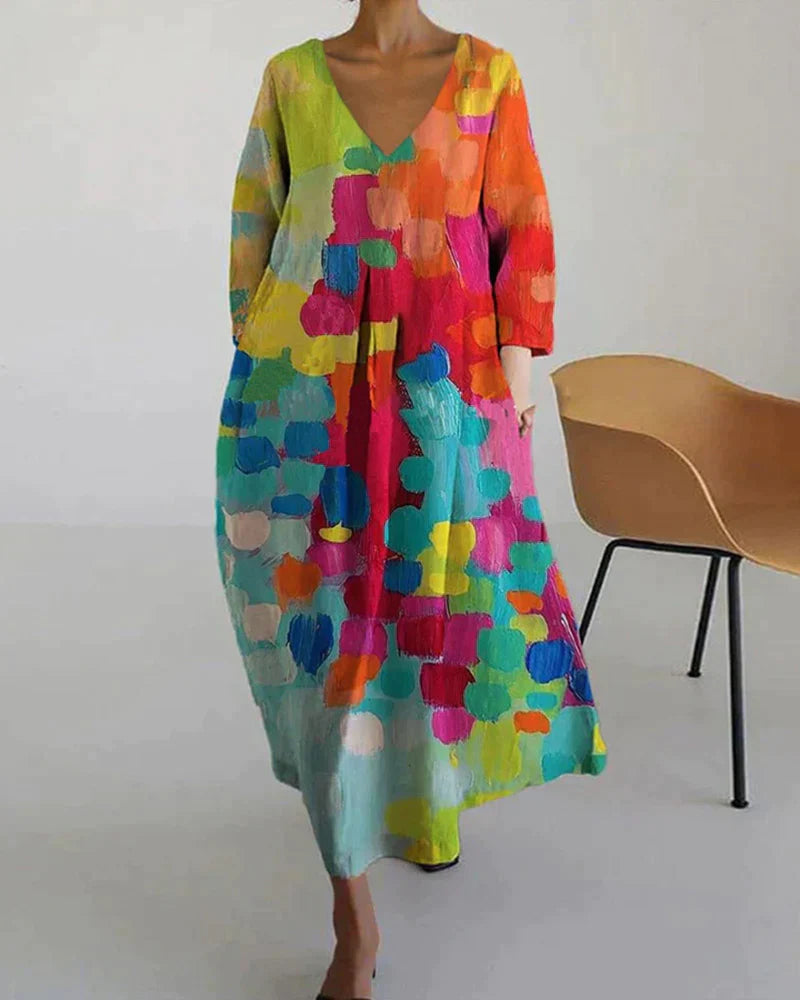 Elegante lange dames zomerjurk met v-hals en flatterende pasvorm, voorzien van een unieke kleurrijke print.