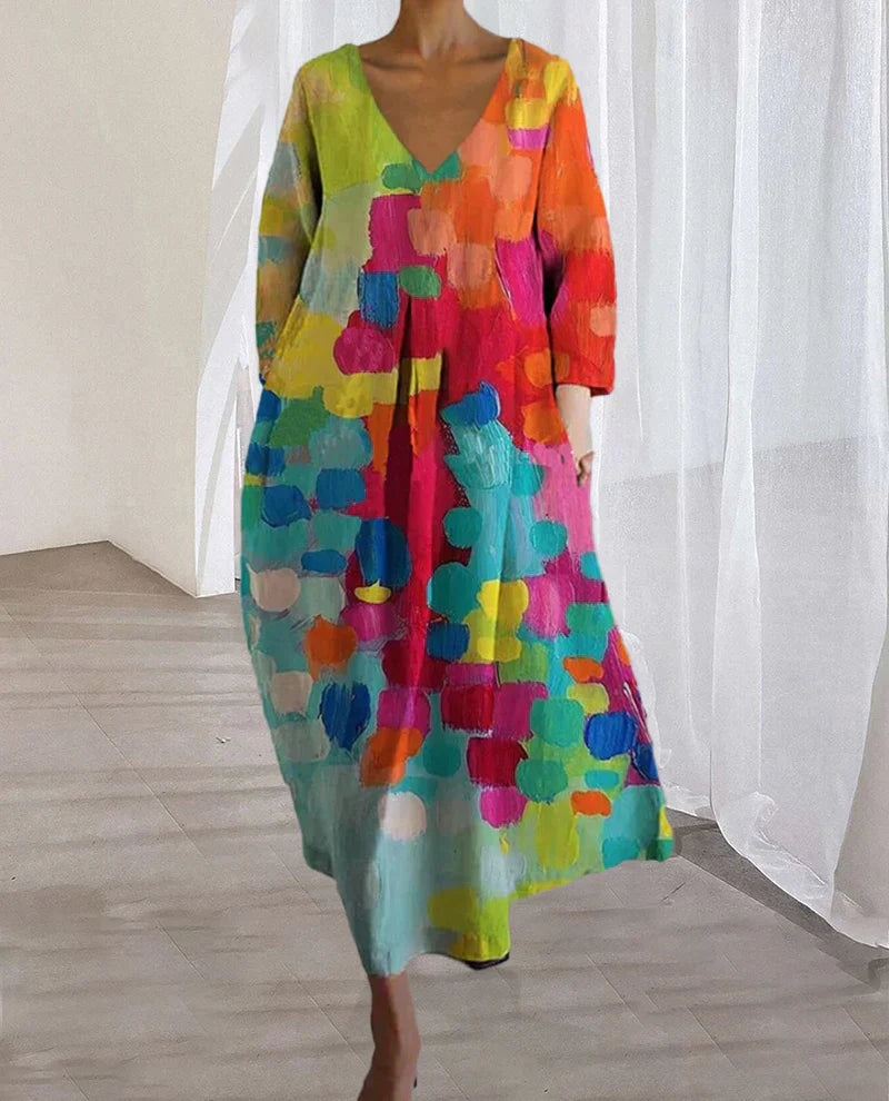 Vrouwelijke lange jurk met v-hals en kleurrijke print, ideaal als lente- of casual jurk met groene en rode tinten.