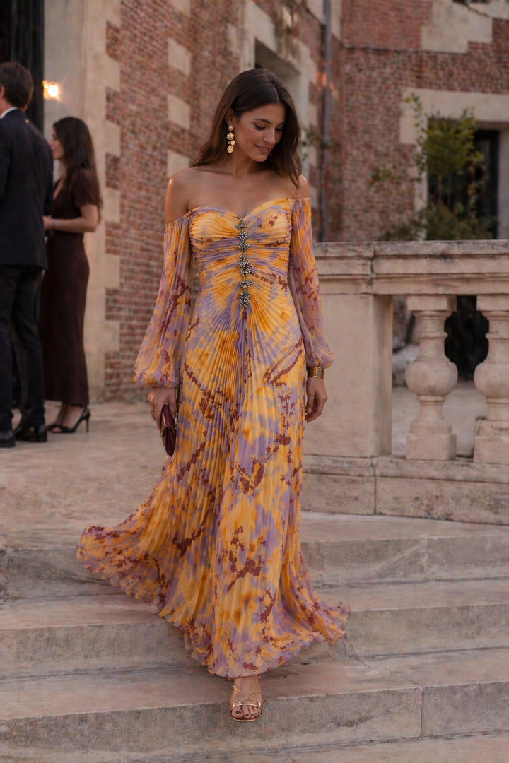 Model draagt lange oranje dames avondjurk met elegante geplooide split, ideaal voor gala.