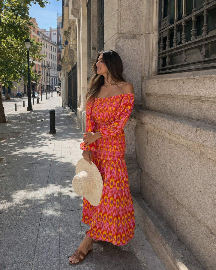 Elegante rode damesjurk met off-shoulder design en ruches, perfect voor speciale zomerse gelegenheden.