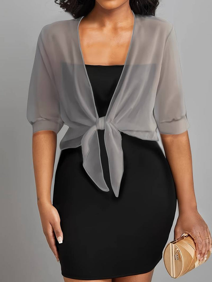 "Luchtige chiffon bolero met striksluiting en korte mouwen, elegant over zomeroutfits. Ideaal voor warme dagen en koele avond