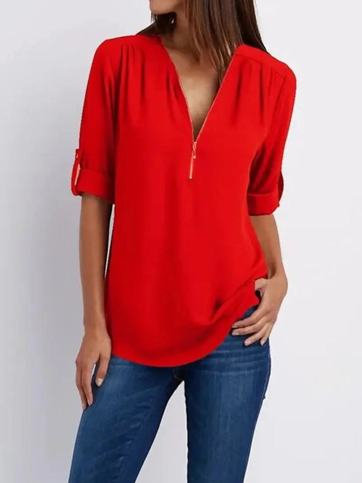 "Luchtige Emilia zomerblouse met v-hals en halve rits in zachte stof, ideaal voor casual zomeroutfits."