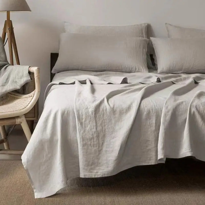 "Luxe linnen beddengoed, elegant en zacht, in diverse kleuren zoals abrikoos en donkergrijs. Perfect voor stijlvol comfort."