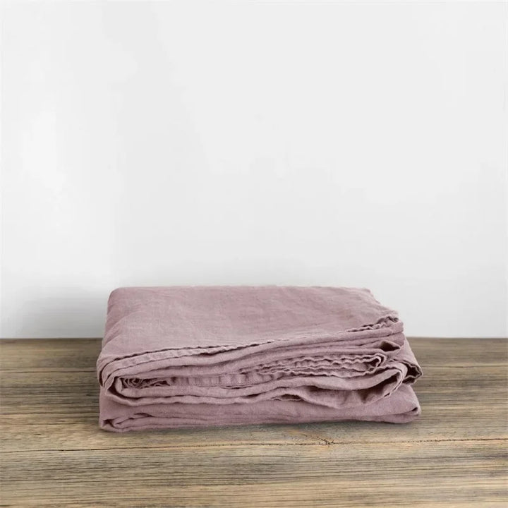 "Luxe linnen beddengoed, elegant en zacht, in diverse kleuren zoals abrikoos en donkergrijs. Perfect voor stijlvol comfort."