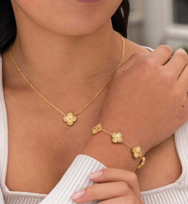 "Luxe sieradenset dames met klaverontwerp, parelmoer coating en gouden details, inclusief ketting, armband en oorbellen."