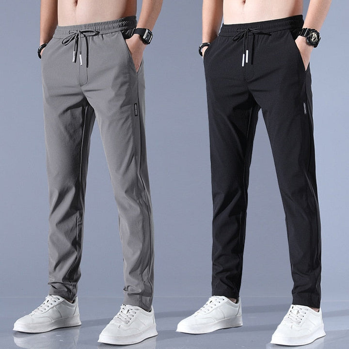 Man beweegt in comfortabele heren sneldrogende stretchbroek; ideaal voor actieve kleding en sport.