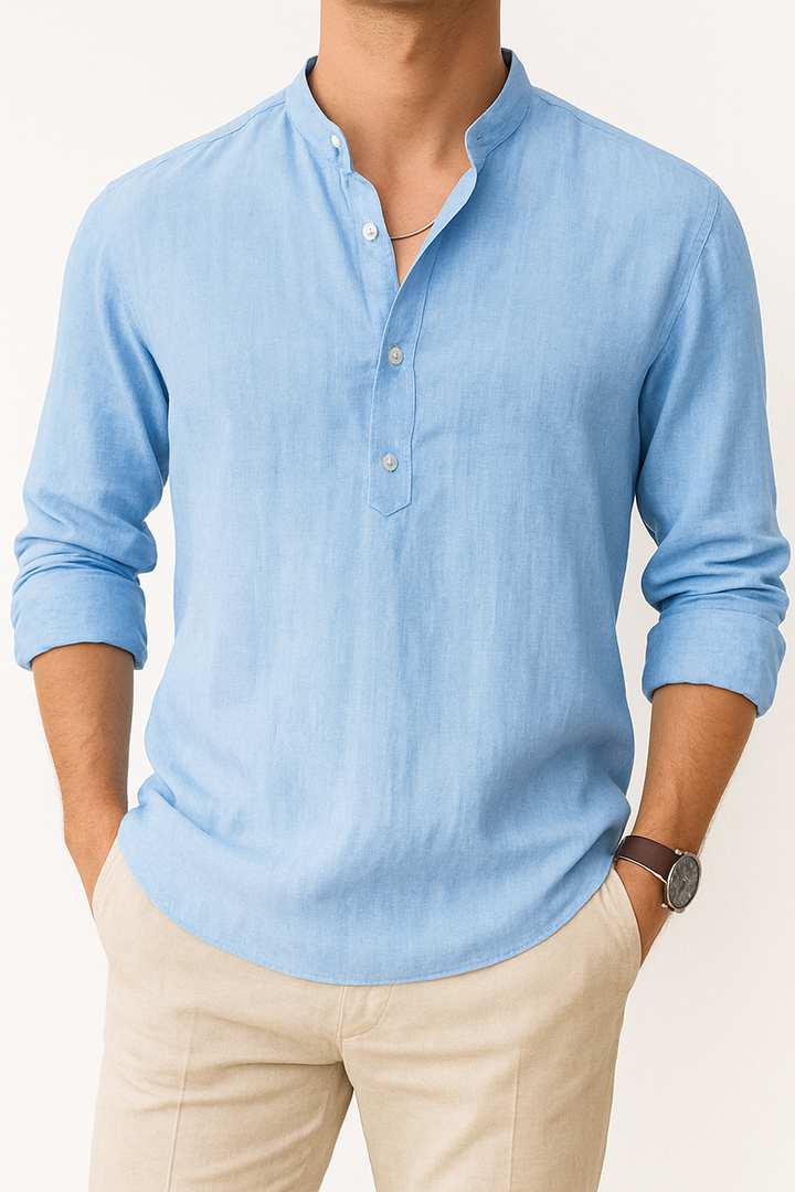 Man draagt luchtig herenoverhemd met Henley kraag, losse pasvorm, ideaal voor zomer en casual strandstijl.