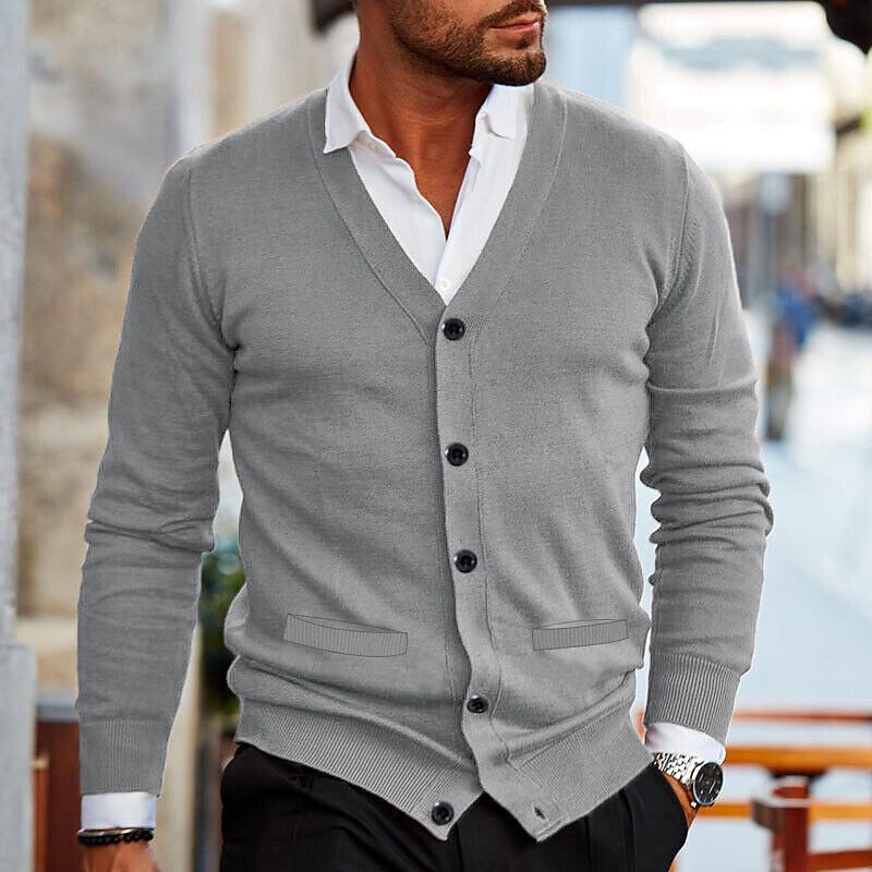 Man draagt stijlvol herenvest, klassieke cardigan over shirt, comfortabele wintermode perfect voor gelaagde look.