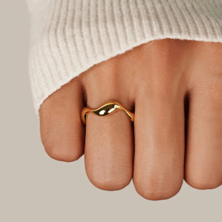 Verfijnde 18K vergulde zilveren damesring met subtiele oceaan golven. Minimalistisch en elegant sieraad.