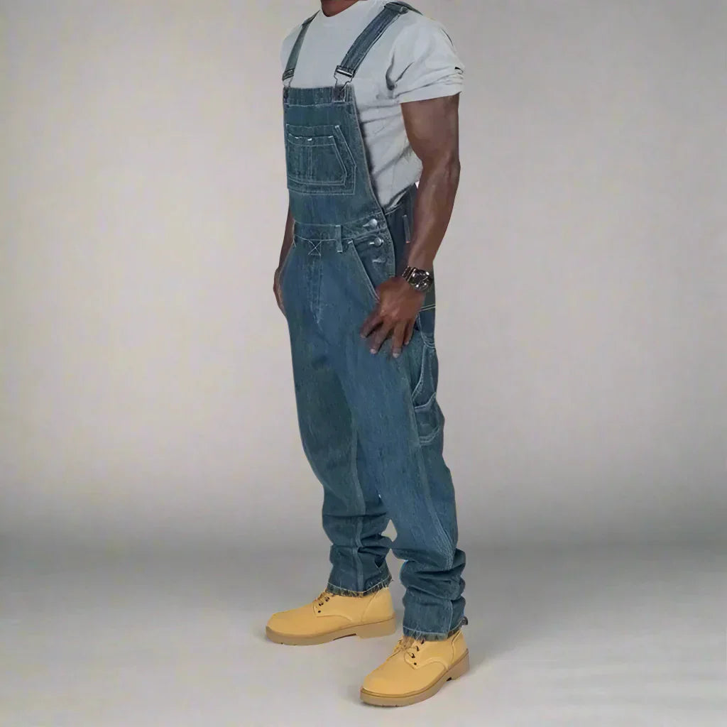 "Moderne denim overall voor heren met splice details, slim fit en rechte pijpen, ideaal als stijlvolle werkkleding."