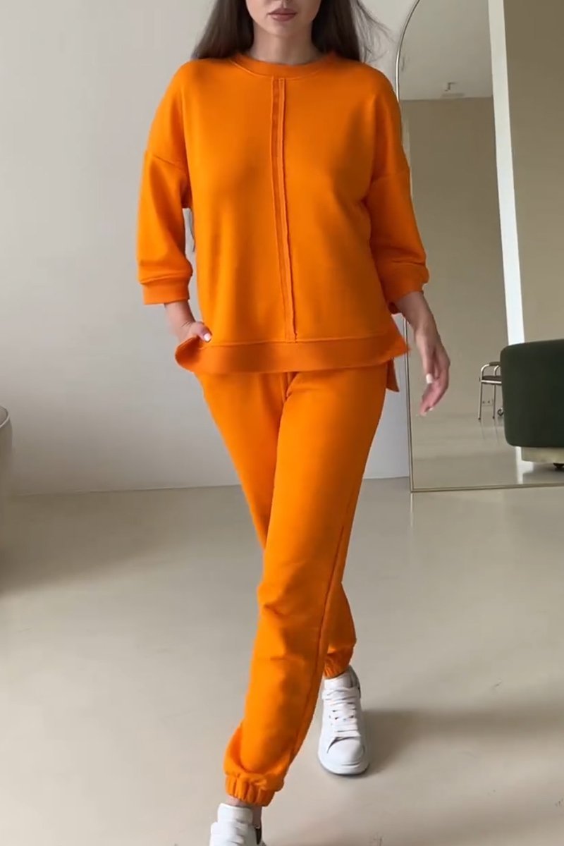 Stijlvolle dames loungewear set in abrikoos, bestaande uit een relaxte trui en comfortabele joggingbroek voor casual mode.