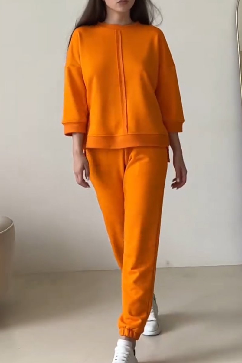 Abrikooskleurige dames co-ord loungewear set: relaxte oversized trui en bijpassende joggingbroek voor stijlvol thuiscomfort.