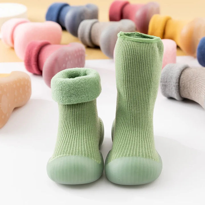 Zachte en flexibele kinderschoenen met sokpasvorm, perfect voor warme voetjes tijdens spelen.