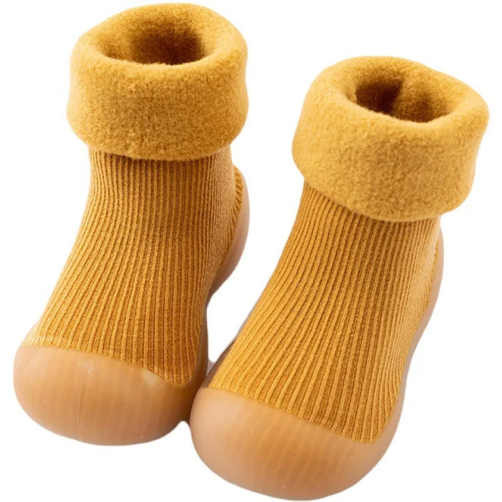 Een paar peuter binnenschoenen in grijze kleur, bieden warmte en bescherming met antislip grip.