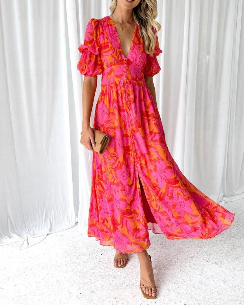 Boheemse dames maxi jurk met levendige tropische print, V-hals en pofmouwen. Ideaal als feestjurk of zomeroutfit.