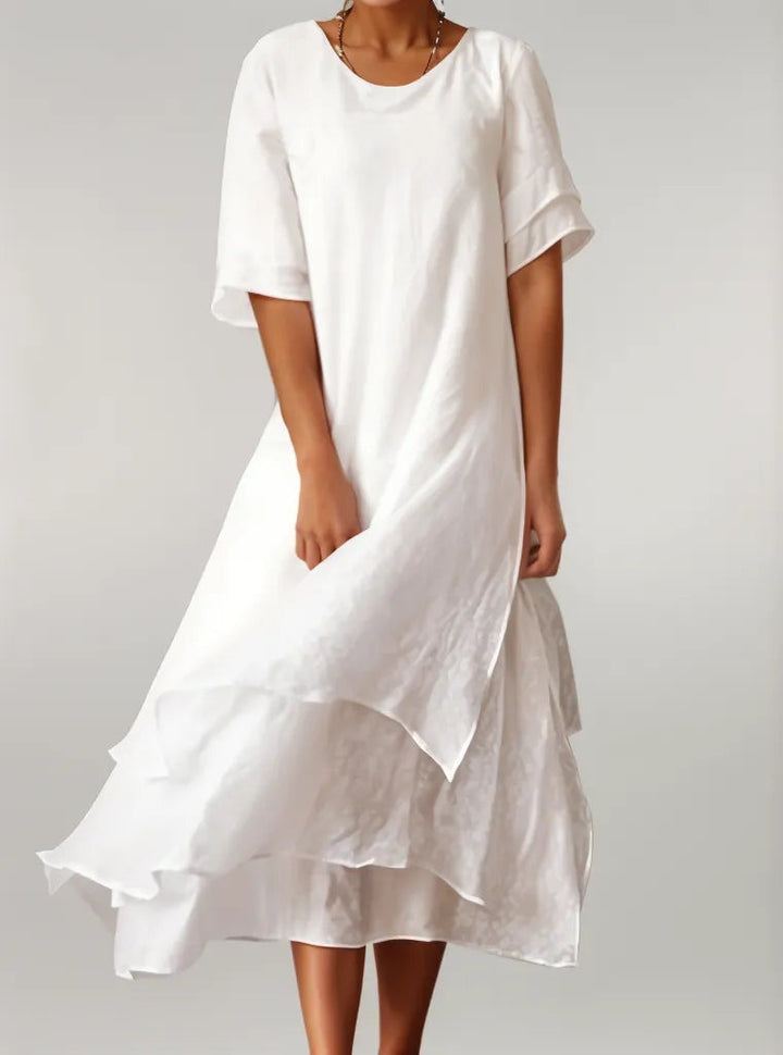 Witte elegante gelaagde damesjurk met vloeiende mouwen, een stijlvolle keuze voor de zomer.