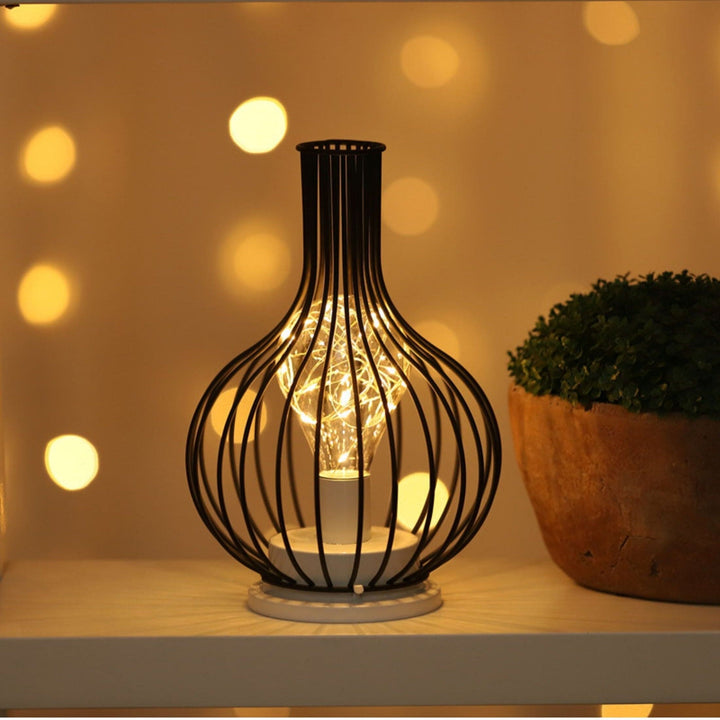 "Rustieke tafellamp met industrieel ontwerp, straalt warm licht uit, ideaal voor sfeerverlichting in moderne interieurs."