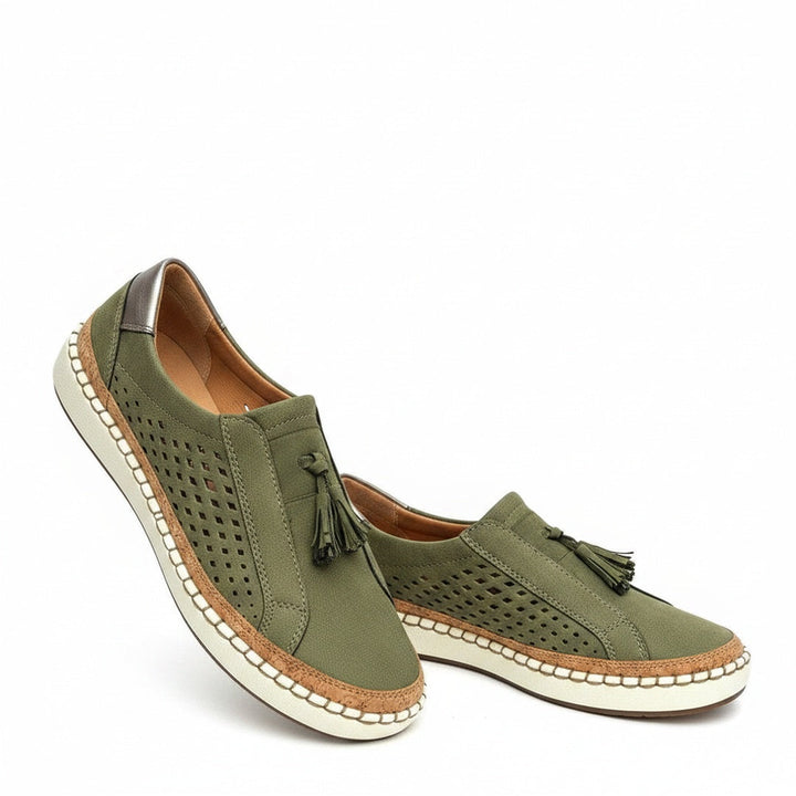 Stijlvolle dames slip-on sneakers met perforaties en decoratieve kwastjes, perfect voor zomerse casual looks.
