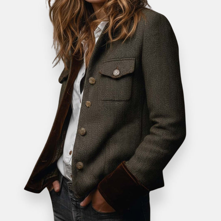 Elegante donkergroene dames blazer met visgraatpatroon en contrasterende manchetten, perfecte herfstmode.