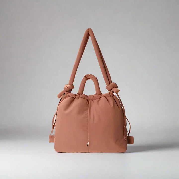 "Stijlvolle puffer handtas in beige met ruim design en comfortabele handgrepen voor vrouwen, perfect voor dagelijks gebruik."