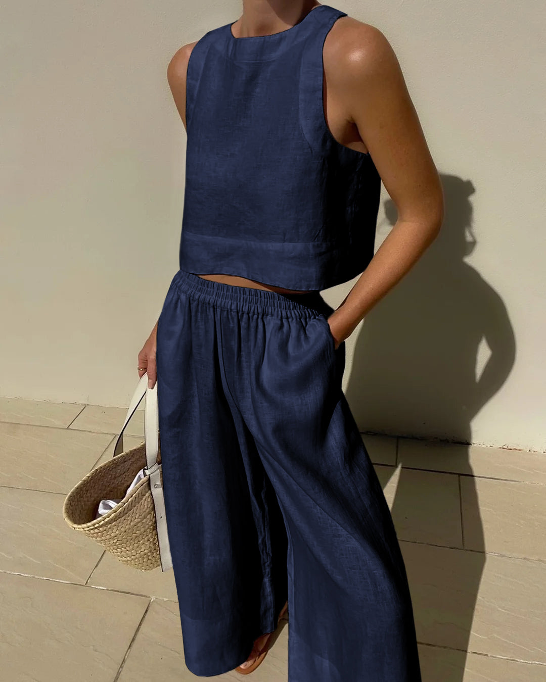"Tweedelige dames set, elegante mouwloze crop top en wijde broek, ideaal voor zomer, stijlvol en verfijnd in beige."