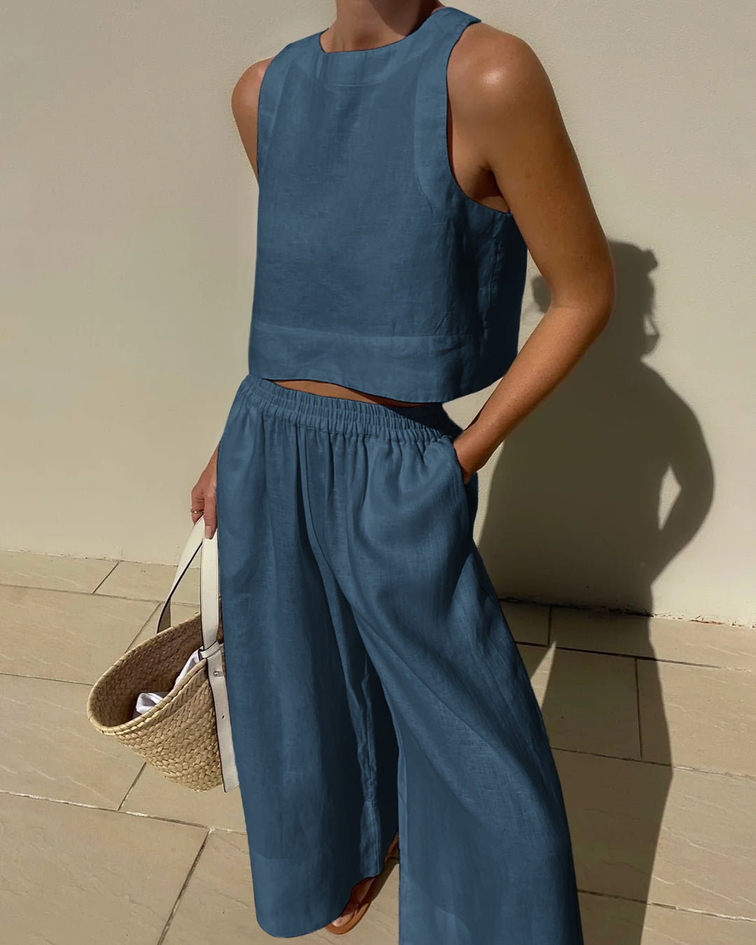"Tweedelige dames set, elegante mouwloze crop top en wijde broek, ideaal voor zomer, stijlvol en verfijnd in beige."