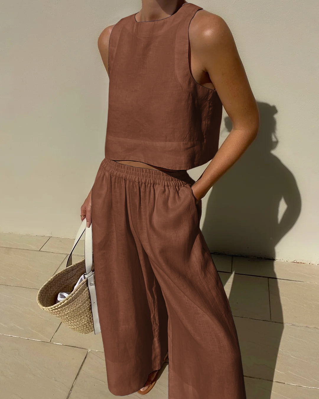 "Tweedelige dames set, elegante mouwloze crop top en wijde broek, ideaal voor zomer, stijlvol en verfijnd in beige."
