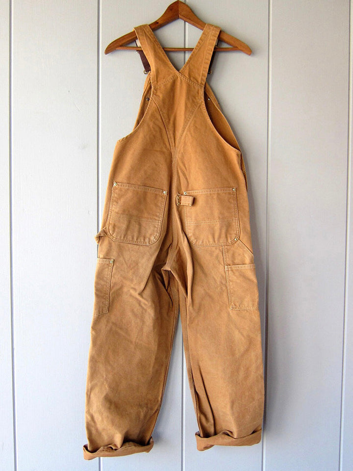 Praktische unisex werkoverall van duurzaam canvas met ruime zakken en verstelbare bretels voor gereedschap.