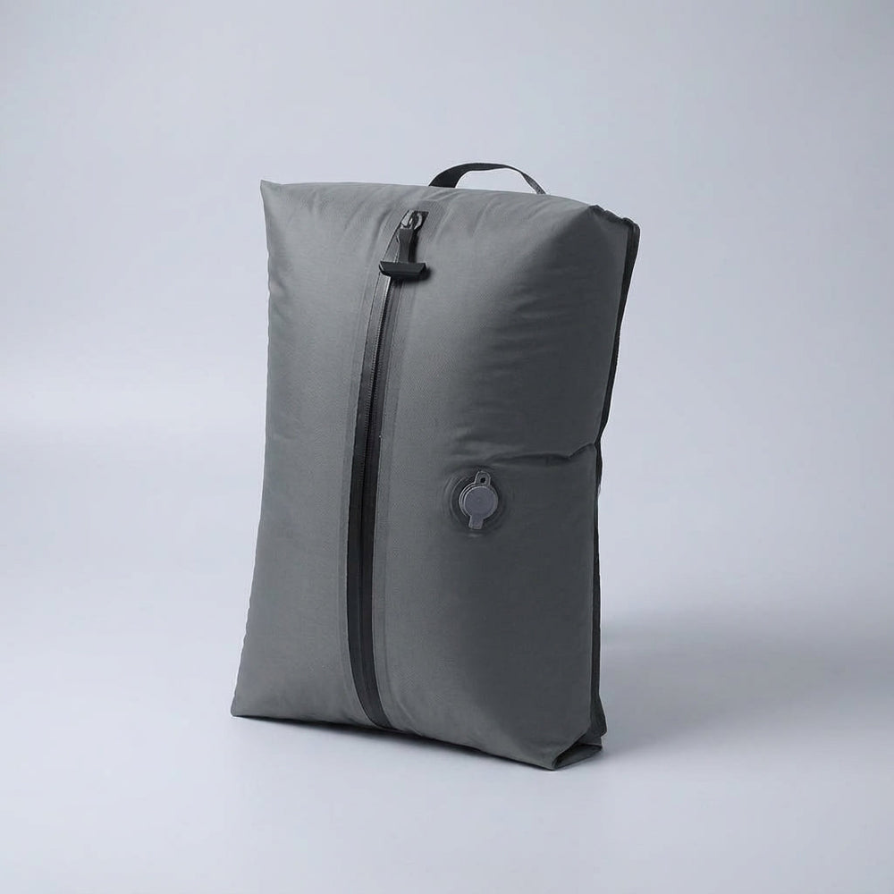 Kleding wordt strak gecomprimeerd in een opvouwbare reistas; ideaal voor ruimtebesparing en organisatie.