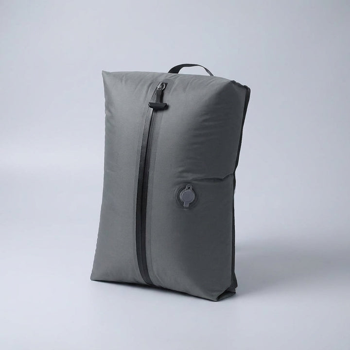 Kleding wordt strak gecomprimeerd in een opvouwbare reistas; ideaal voor ruimtebesparing en organisatie.