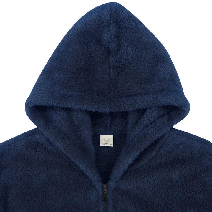 Close-up van de rits en capuchon op een warm zwart herenvest, comfortabel voor koude winterdagen.