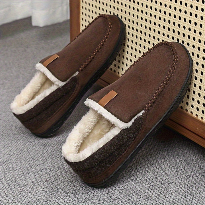 Man draagt warme heren loafers pantoffels, genietend van thuiscomfort.