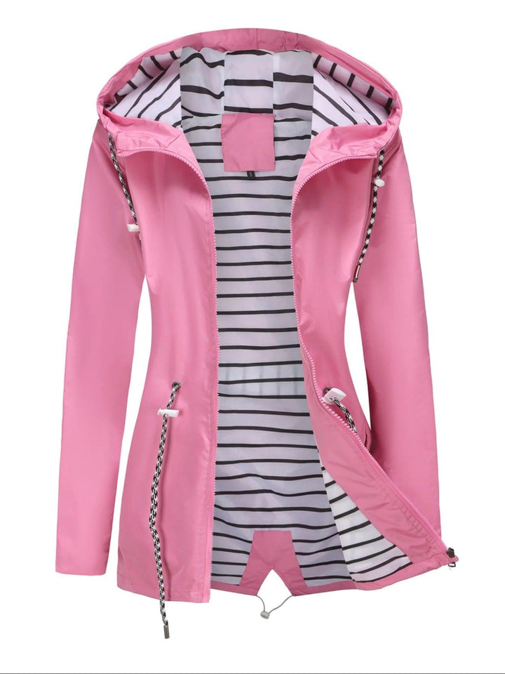 "Weerbestendige damesjas met capuchon in herfstkleuren, wind- en waterdicht, perfect voor regenachtig weer."