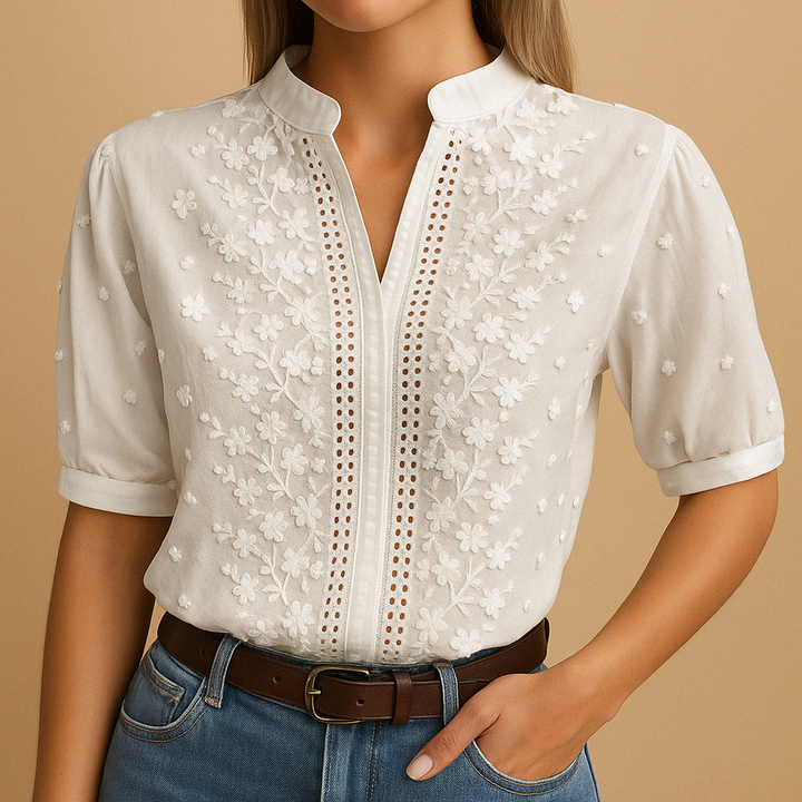 Casual chic witte dames blouse met ajour detail, V-hals en korte pofmouwen, verrijkt met delicaat bloemborduursel.