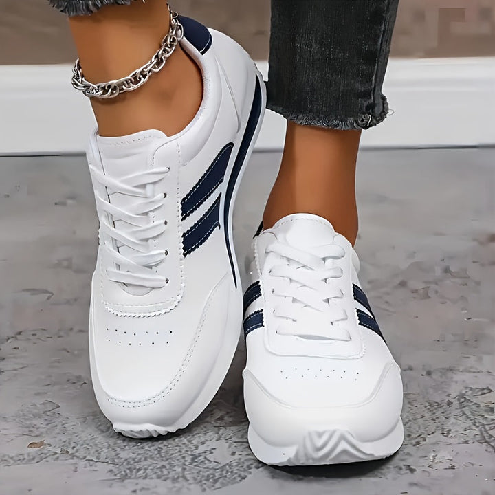 Lage dames sneakers, wit, met gestructureerde zool en veters; een comfortabele dagelijkse schoen.