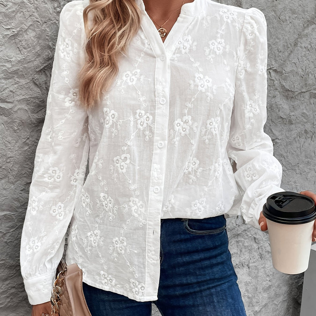 Witte damesblouse met lange mouwen en delicaat detail, perfect voor elegante lente mode.