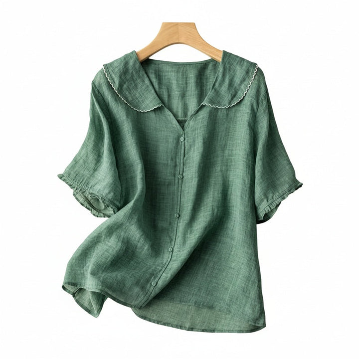Witte damesblouse met peterpankraag, korte mouwen en knoopsluiting. Elegante vintage stijl zomerblouse.