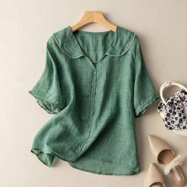 Close-up van de peterpankraag en de losvallende korte mouwen van deze comfortabele damesblouse.