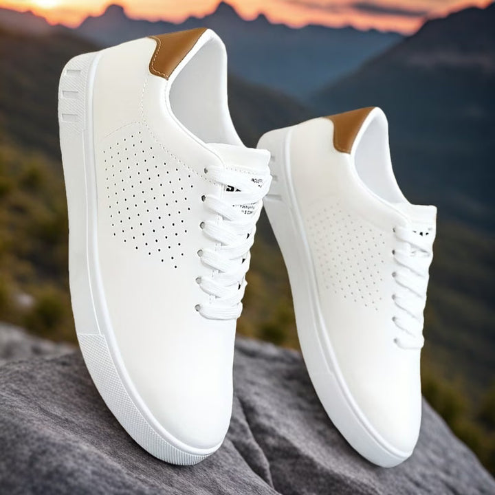 Detailfoto van geperforeerde neus op comfortabele witte heren low-top sneakers met vetersluiting.