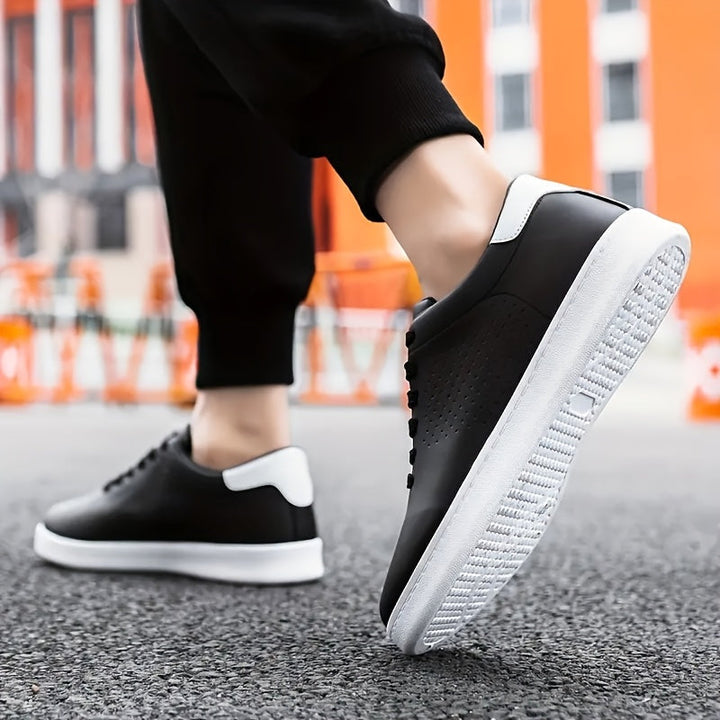 Close-up van de vetersluiting op stijlvolle zwarte heren low-top sneakers met geperforeerde details.