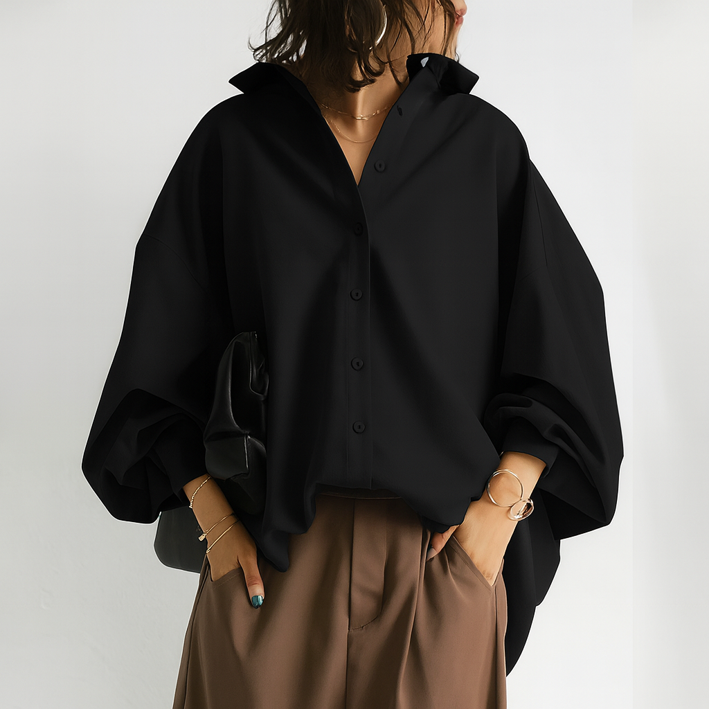 Zwarte damesblouse met lange ballonmouwen en hemdkraag, een modieuze oversized stijl voor zowel casual als chique gelegenheden.