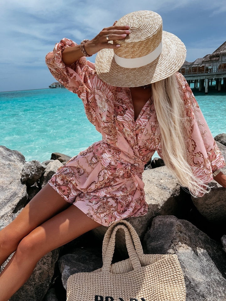 "Zomerse playsuit met V-hals, fruit- en bladmotieven, kleurrijke tropische print, accentueert silhouet en biedt comfort."