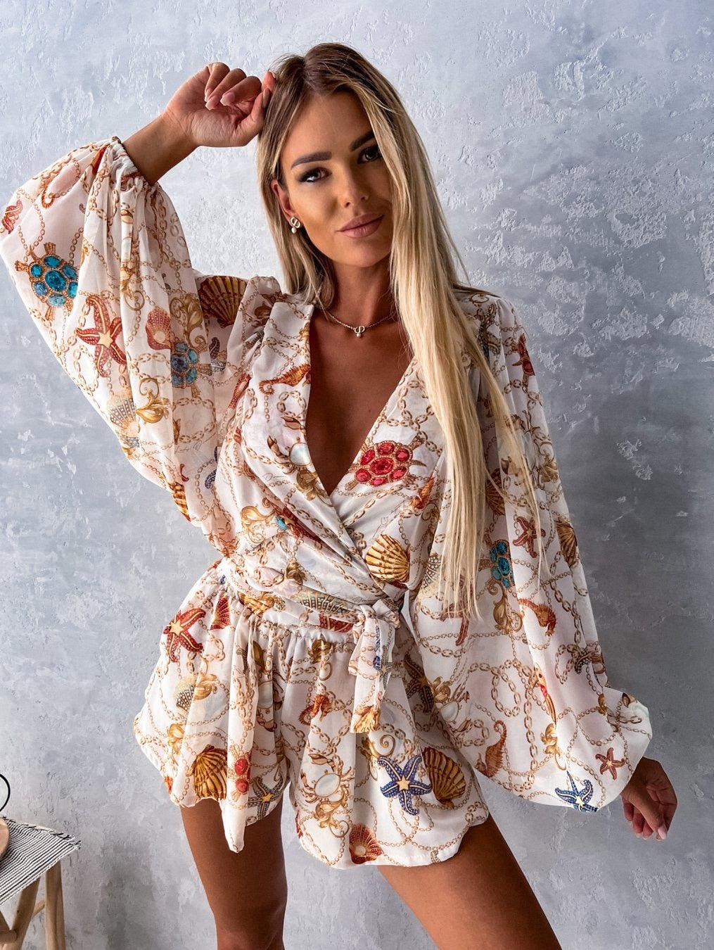 "Zomerse playsuit met V-hals, fruit- en bladmotieven, kleurrijke tropische print, accentueert silhouet en biedt comfort."