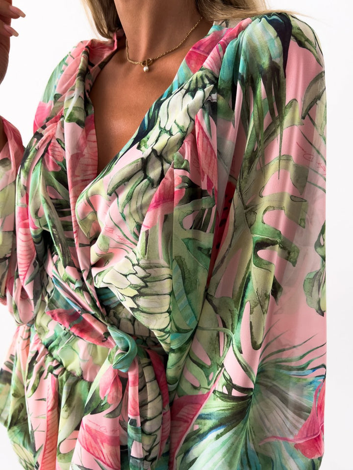 "Zomerse playsuit met V-hals, fruit- en bladmotieven, kleurrijke tropische print, accentueert silhouet en biedt comfort."